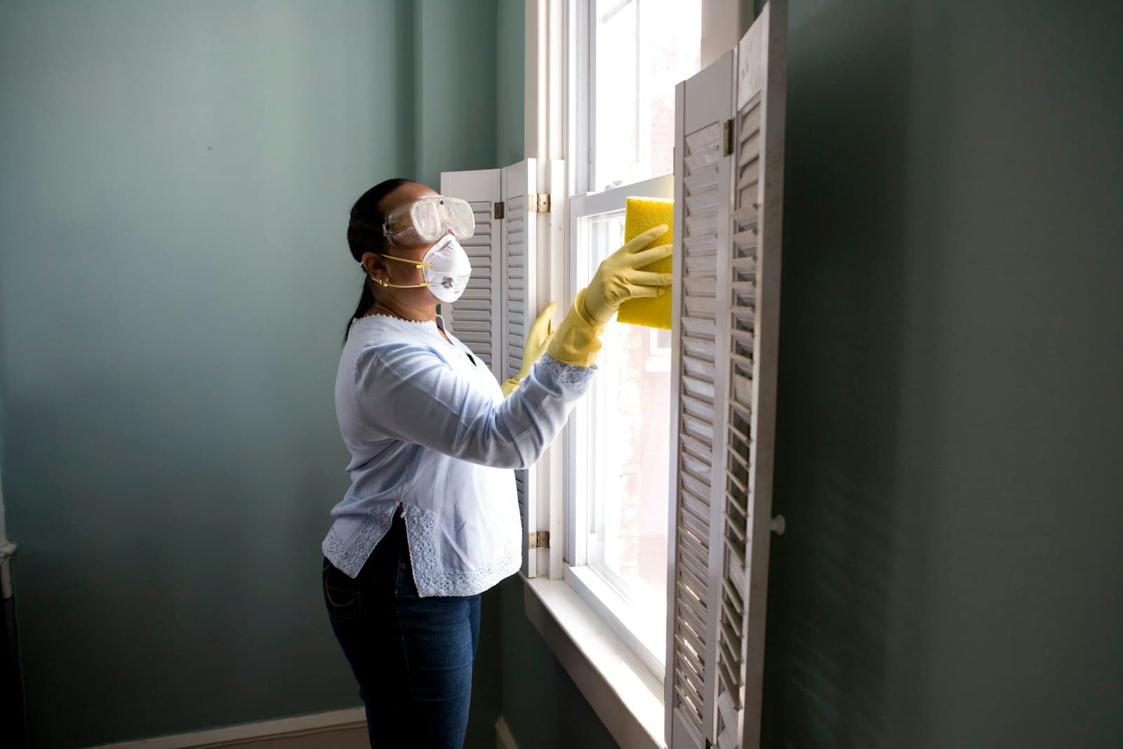Professional cleaner cleaning a window in an Aylesbury home